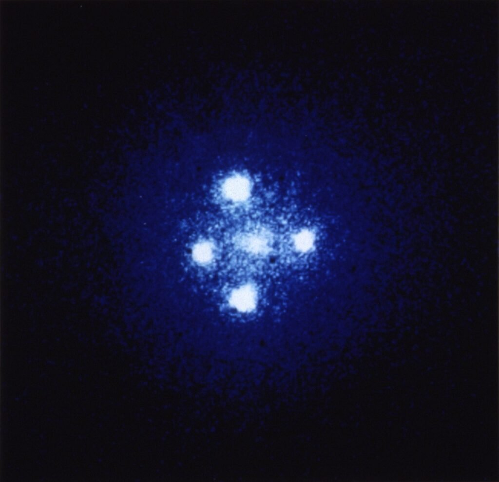Hubble ile görüntülenen Einstein Haçı: kütleçekim merceği etkisiyle dört görüntüye bölünmüş uzak bir kuasar